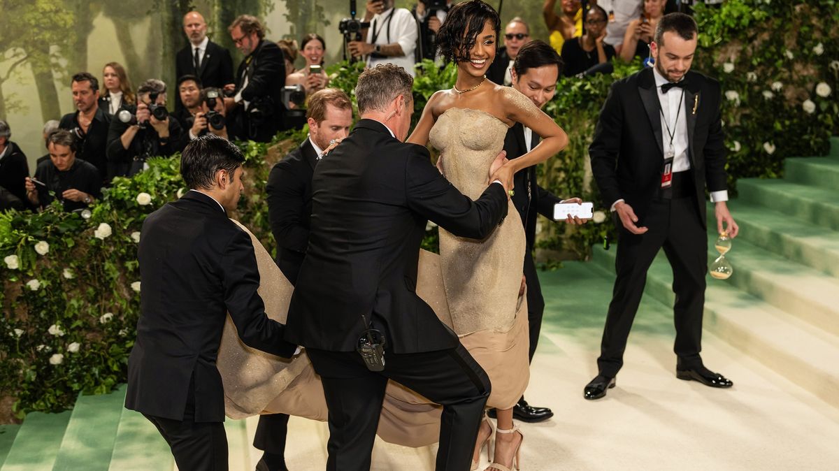 这位歌手穿着沙色连衣裙参加 Met Gala。 她不能走路，他们必须像活娃娃一样背着她上楼梯！