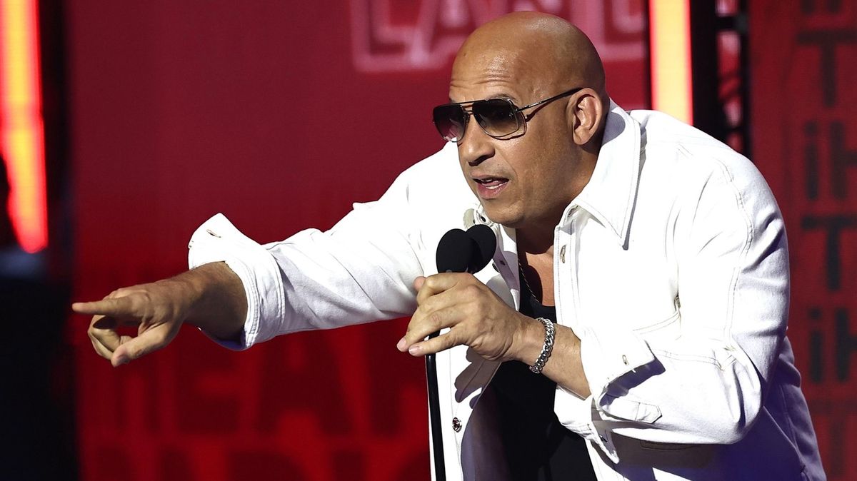 Vin Diesel je slepý jako patrona. Řídit rychle a zběsile by už rozhodně neměl! Na pódiu marně hledal čtecí zařízení
